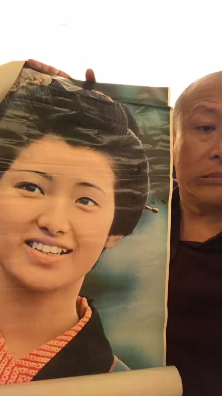 山口百惠的印刷肖像旁,露出仁波切的半张脸。