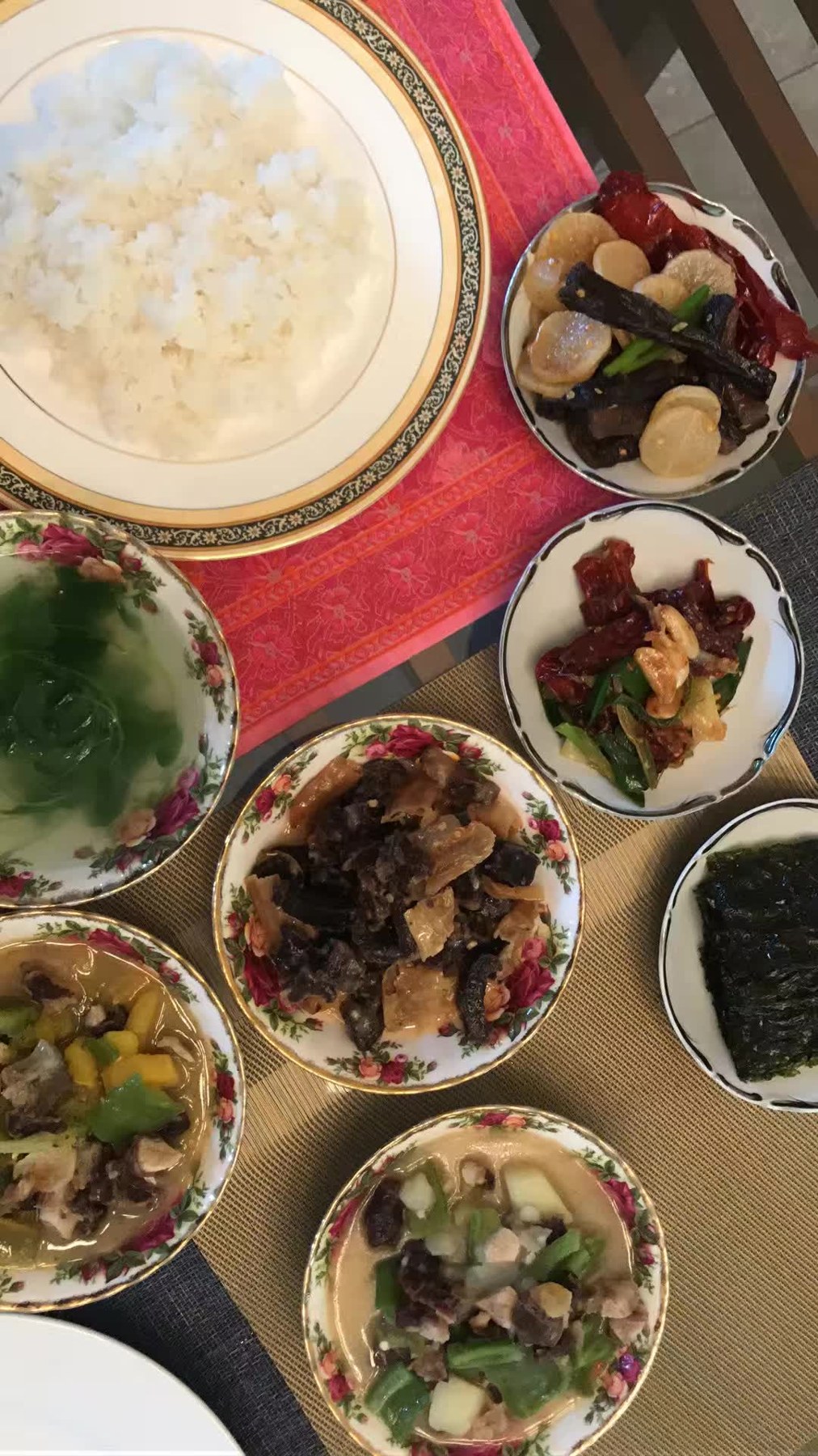 白米饭与多碗菜摆在一起，碗沿有红色花纹。