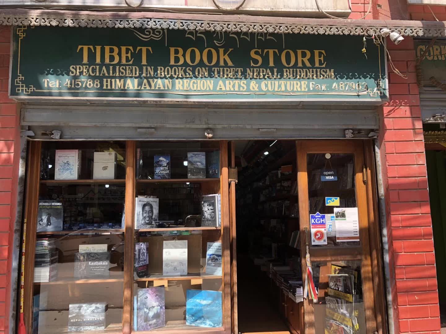 红砖门脸上的绿色招牌写着TIBET BOOK STORE，玻璃橱窗里陈列着书。
